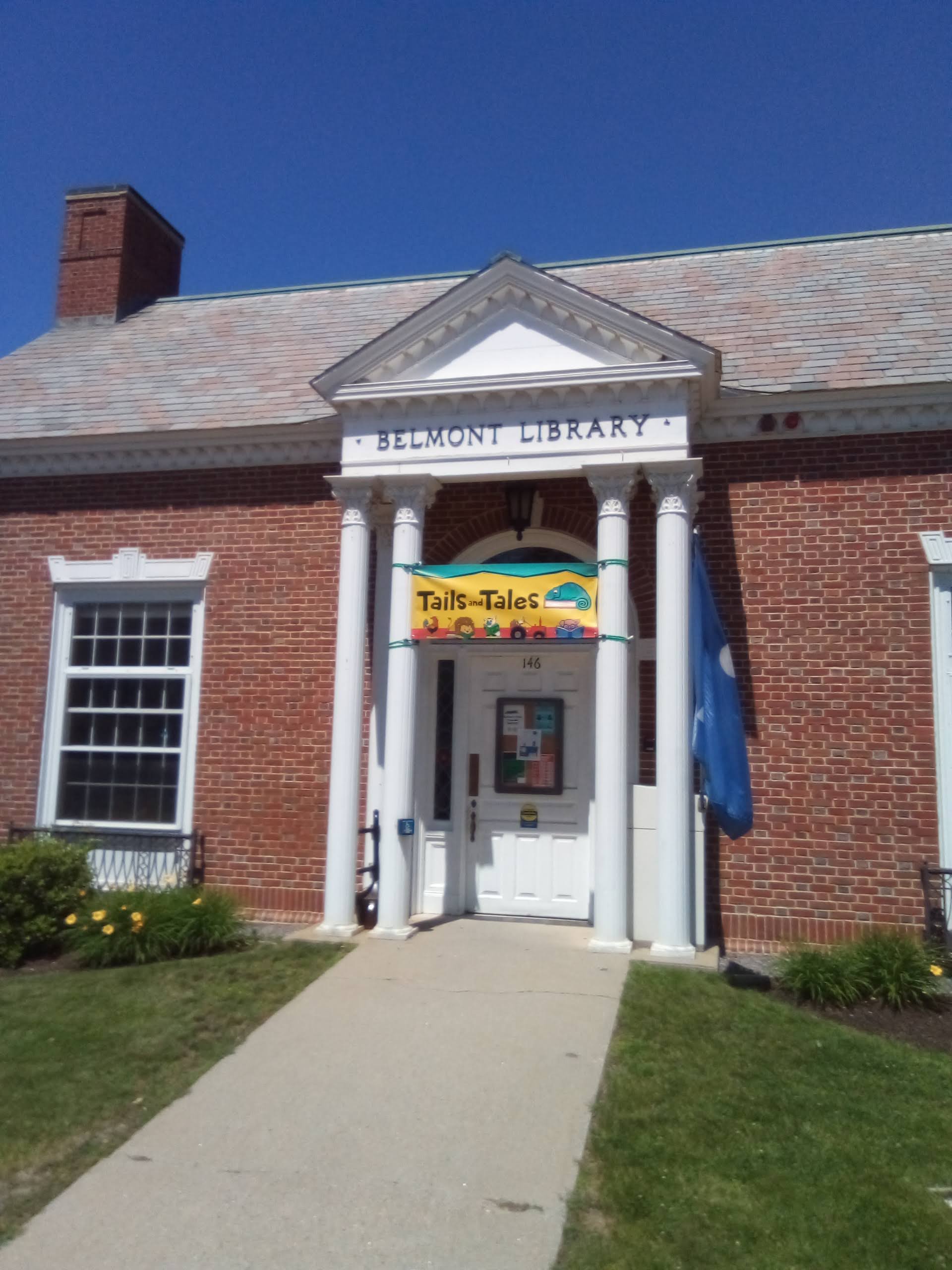 Photo of the Belmont Library with a Banner for the "Tails and Tales " event
